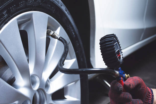 istock Car mechanic checks tire pressure 1248953802