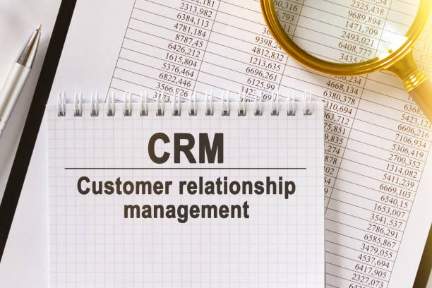istock On the table are financial reports, a pen, a magnifying glass and a notebook with the inscription - CRM. 1248954757