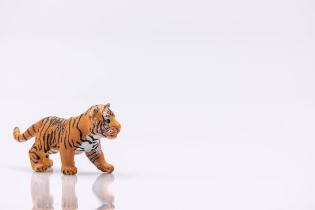 close up of a baby tiger from a plastic toy isolated on a white background
