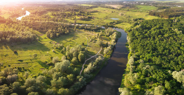 istock Evening aerial view on river bend with sunlight on horizon. 1248961435
