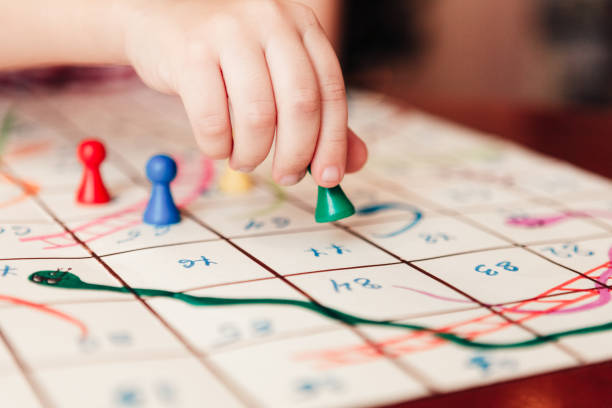 Kids hand with green chip under the board game
