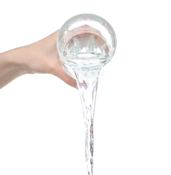 istock Water is pouring from a glass in hand 1248964649