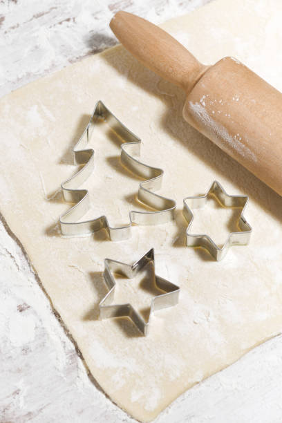 istock the sheet of dough on the table, cookie cutters and rolling pin, top view vertical 1248966637