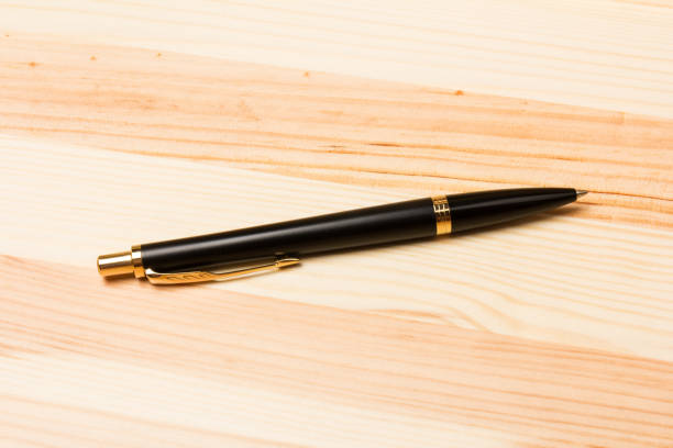 木製の背景に黒いペン。ビジネスコンセプト - pen writing instrument pencil gold ストックフォトと画像