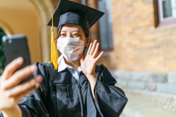 istock Student in graduation gown making video call with smart phone 1248972783