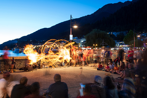 Queenstown, New Zealand - December 25, 2018. Tourists watching a street artist playing with fire in Queenstown on South Island, New Zealand.