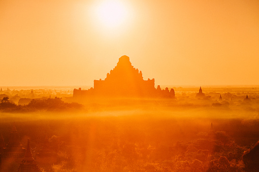 Scenic sunrise with many hot air balloons above Bagan Dhammayangyi temple in Myanmar. Bagan is an ancient city with thousands of historic buddhist temples and stupas.
