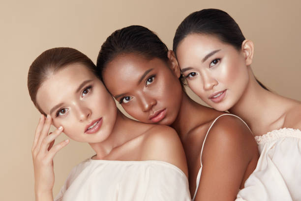 schönheit. gruppe von vielfalt modelle portrait. multi-ethnische frauen mit verschiedenen hauttypen posiert auf beige hintergrund. zarte multikulturelle mädchen, die zusammenstehen und in die kamera schauen. - human age multi ethnic group variation group of people stock-fotos und bilder