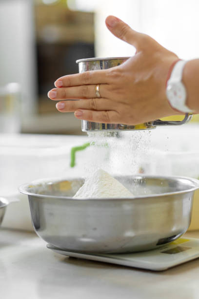 cozinhando cozimento. cozinhe peneira a farinha um - cake making mixing eggs - fotografias e filmes do acervo