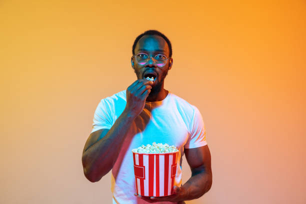 istock African-american man's portrait isolated on gradient orange studio background in neon light 1248978578