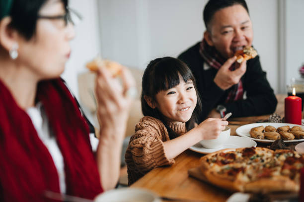 fröhliche asiatische mehrgenerationenfamilie feiert weihnachten und verbringt zeit miteinander, um die weihnachtsfeier zu hause zu genießen - asian cuisine lunch dinner food stock-fotos und bilder