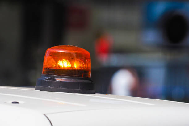 Close-up photograph on a red flashing light. In the background, pink/purple lights are on the left. The rotating beacon is on and illuminates from the front. You might think like a police siren, but it's a merry-go-round flashing light.