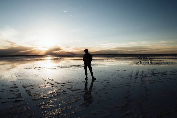 istock Man is walking in Salar de Uyuni at the sunset 1248981296
