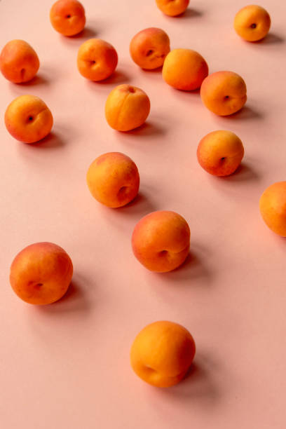istock Orange apricots scattered on a pink table 1248981626