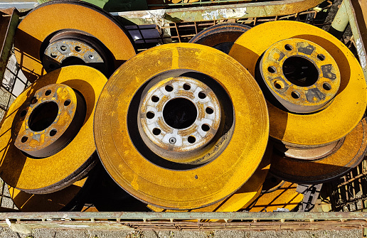 Old rusted car brake discs on a scrap yard