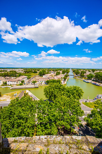 France. Shipping channel flows into the Mediterranean Sea. Antique walls of the medieval port city of Aigues-Mortes. Yachts moored off the coast. The concept of historical and photo tourism