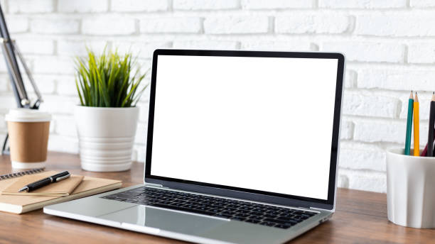 istock laptop computer with blank white screen, with workspace and office supplies on a wooden desk 1248982598
