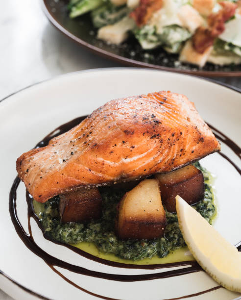 istock Salmon steak with baked potato, spinach and lemon on a marble table 1248982889