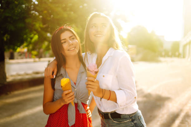 istock Two young female friends having fun and eating ice cream. 1248984187