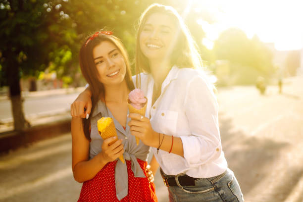 istock Two young female friends having fun and eating ice cream. 1248984227