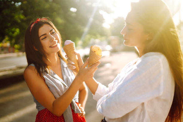 istock Two young female friends having fun and eating ice cream. 1248984277