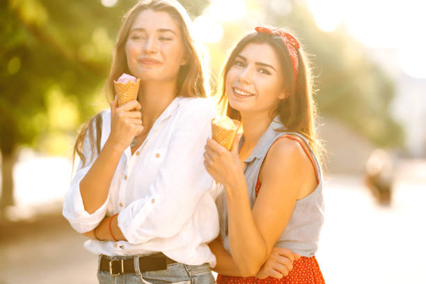 istock Two young female friends having fun and eating ice cream. 1248984310