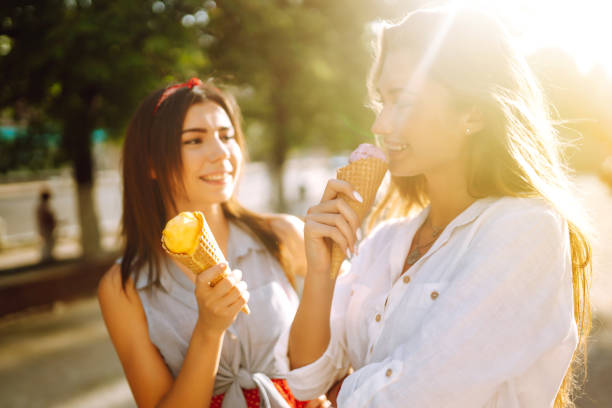 istock Two young female friends having fun and eating ice cream. 1248984315