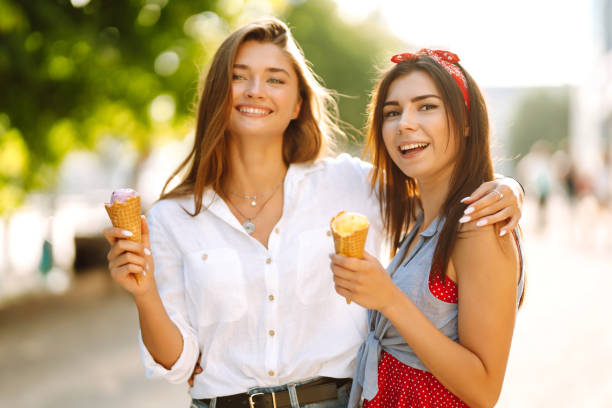 istock Two young female friends having fun and eating ice cream. 1248984320