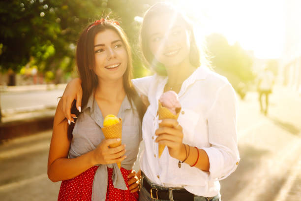 istock Two young female friends having fun and eating ice cream. 1248984349
