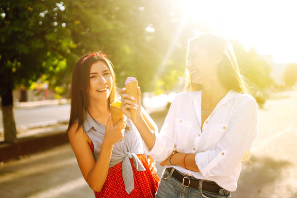 istock Two young female friends having fun and eating ice cream. 1248984354