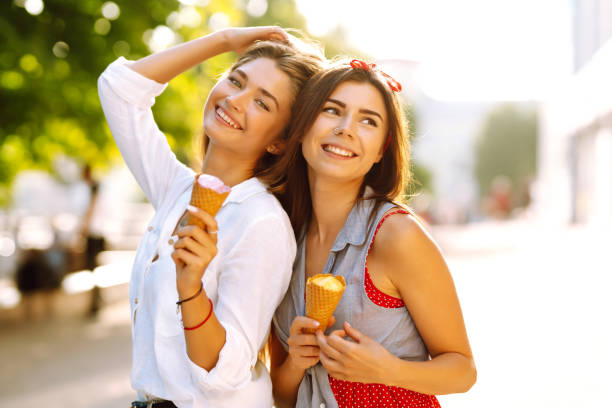 istock Two young female friends having fun and eating ice cream. 1248984477
