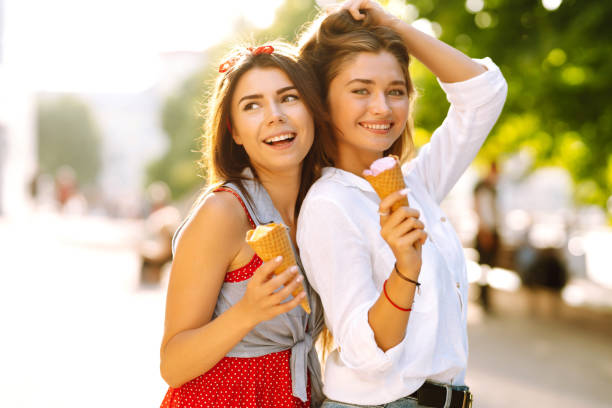 istock Two young female friends having fun and eating ice cream. 1248984610