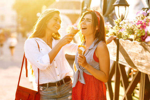 istock Two young female friends having fun and eating ice cream. 1248984775