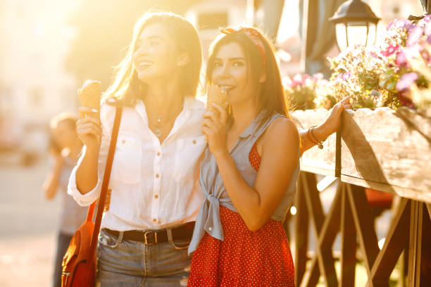 istock Two young female friends having fun and eating ice cream. 1248984789