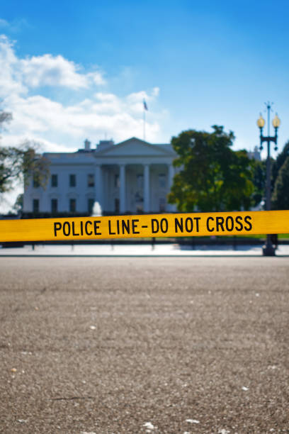 Police line tape in front of the White House. With copyspace. Yellow POLICE LINE - DO NOT CROSS barricade tape in front of the White House. With copyspace for text. white house barrier stock pictures, royalty-free photos & images