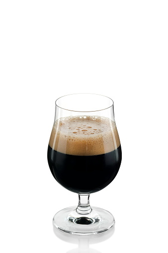 black beer being poured into a specific glass