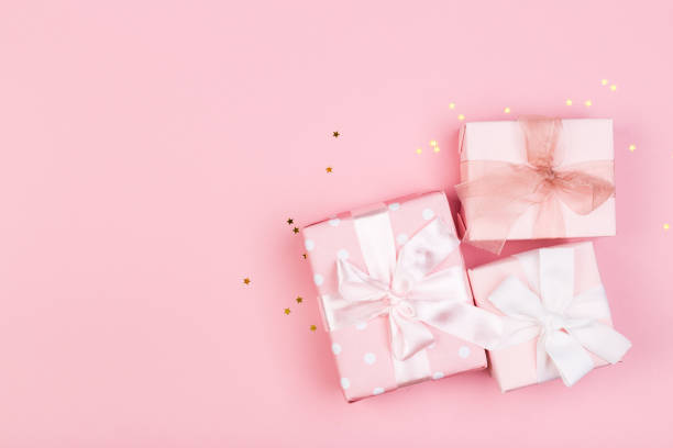 istock Gift or gift box and stars confetti on a pink table from above. Flat composition for birthday, mothers day or wedding. 1248991877