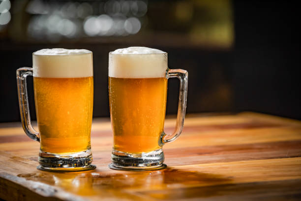 istock Two mugs full of chopp, one with pilsen chopp and one with dark chop on a rustic table. 1248993001