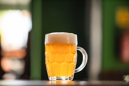 A glass of beer with froth head on a white background with clipping path.  Please see my portfolio for other food and drink images. 