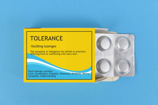 Concept for tolerance with open package of lozenges with made up label for medication to help people be more tolerante Concept for tolerance with yellow open package of lozenges with made up label for medication to help people be more tolerante on blue background cough lozenge stock pictures, royalty-free photos & images