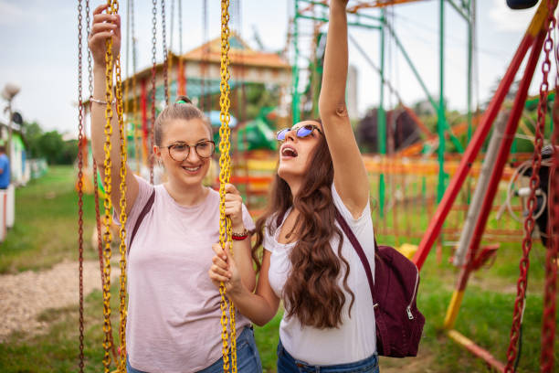 dwie dziecinne dziewczyny w parku rozrywki - amusment park zdjęcia i obrazy z banku zdjęć