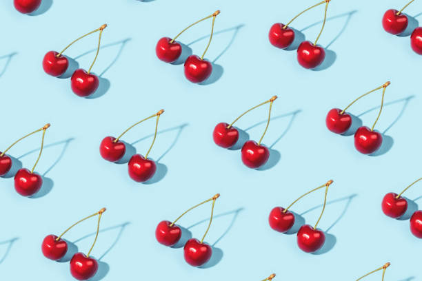 Bright pattern of ripe cherries on a blue background.