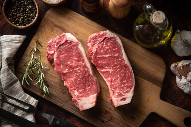 istock raw strip beef steak meat on wooden cutting board 1248998457