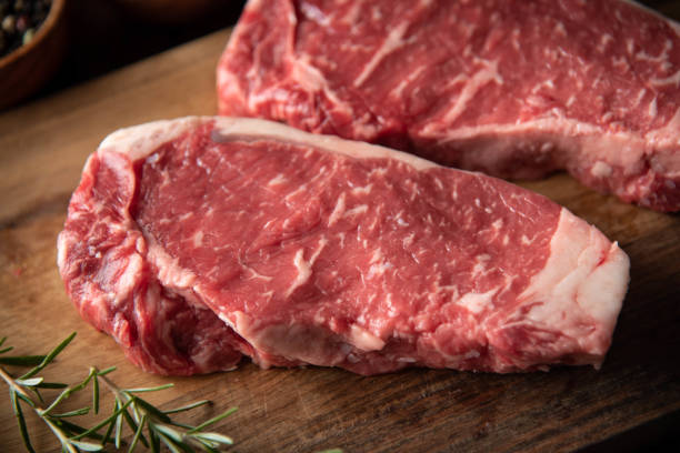 istock raw strip beef steak meat on wooden cutting board 1248998607