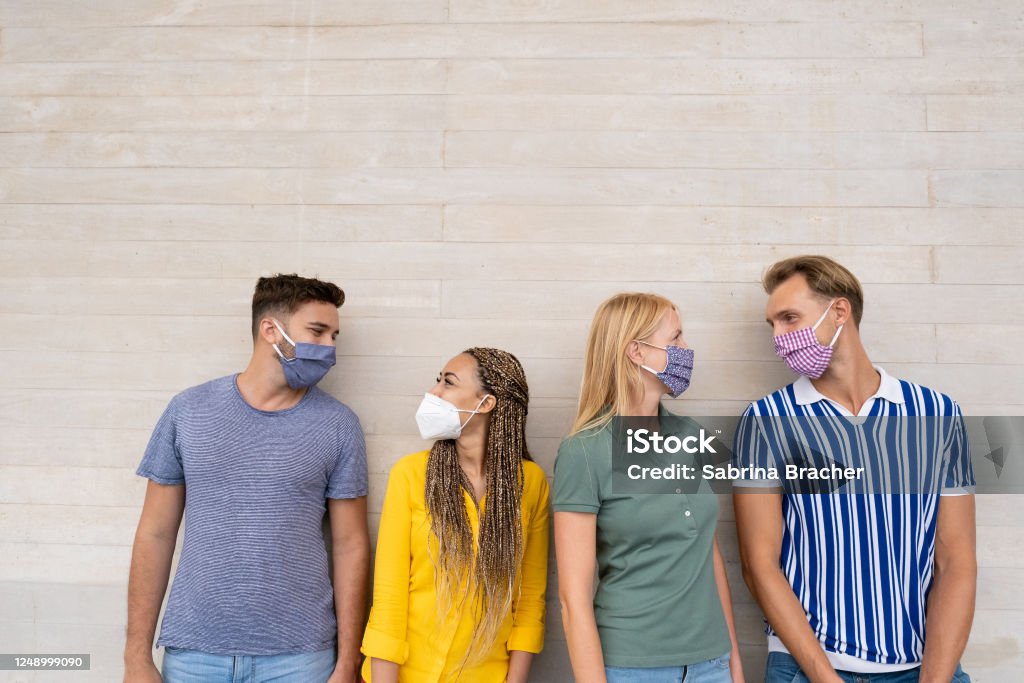 Happy multiracial friends smiling and look eachother - Group of mixed race people wearing protective face mask - Concept of health care and social contact in time of coronavirus Latin American and Hispanic Ethnicity Stock Photo