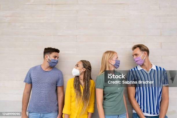 Happy Multiracial Friends Smiling And Look Eachother Group Of Mixed Race People Wearing Protective Face Mask Concept Of Health Care And Social Contact In Time Of Coronavirus Stock Photo - Download Image Now