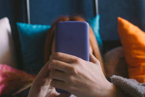 istock Adult woman using mobile phone at her bed 1249000066