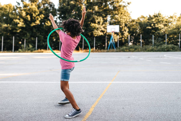 istock Girl with hoola hoop on playground 1249001278