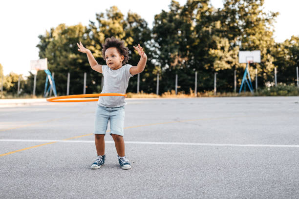 девушка с хула обруч на детской площадке - schoolyard playground playful playing стоковые фото и изображения