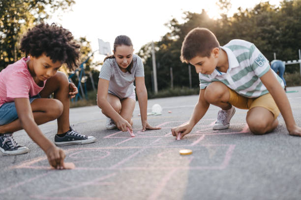 istock Friends drawing hopscotch court using chalk 1249002234
